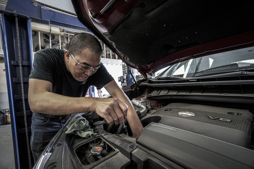 Car mechanic inspecting the engine bay of a vehicle